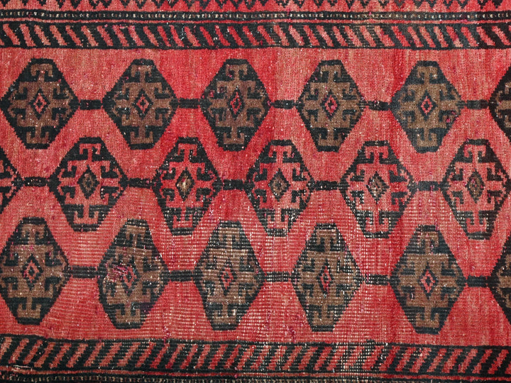 a red and black rug with a pattern of hexagonal shapes