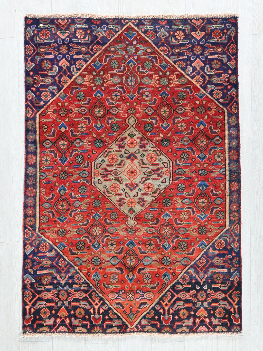 a red and blue rug on a white wall