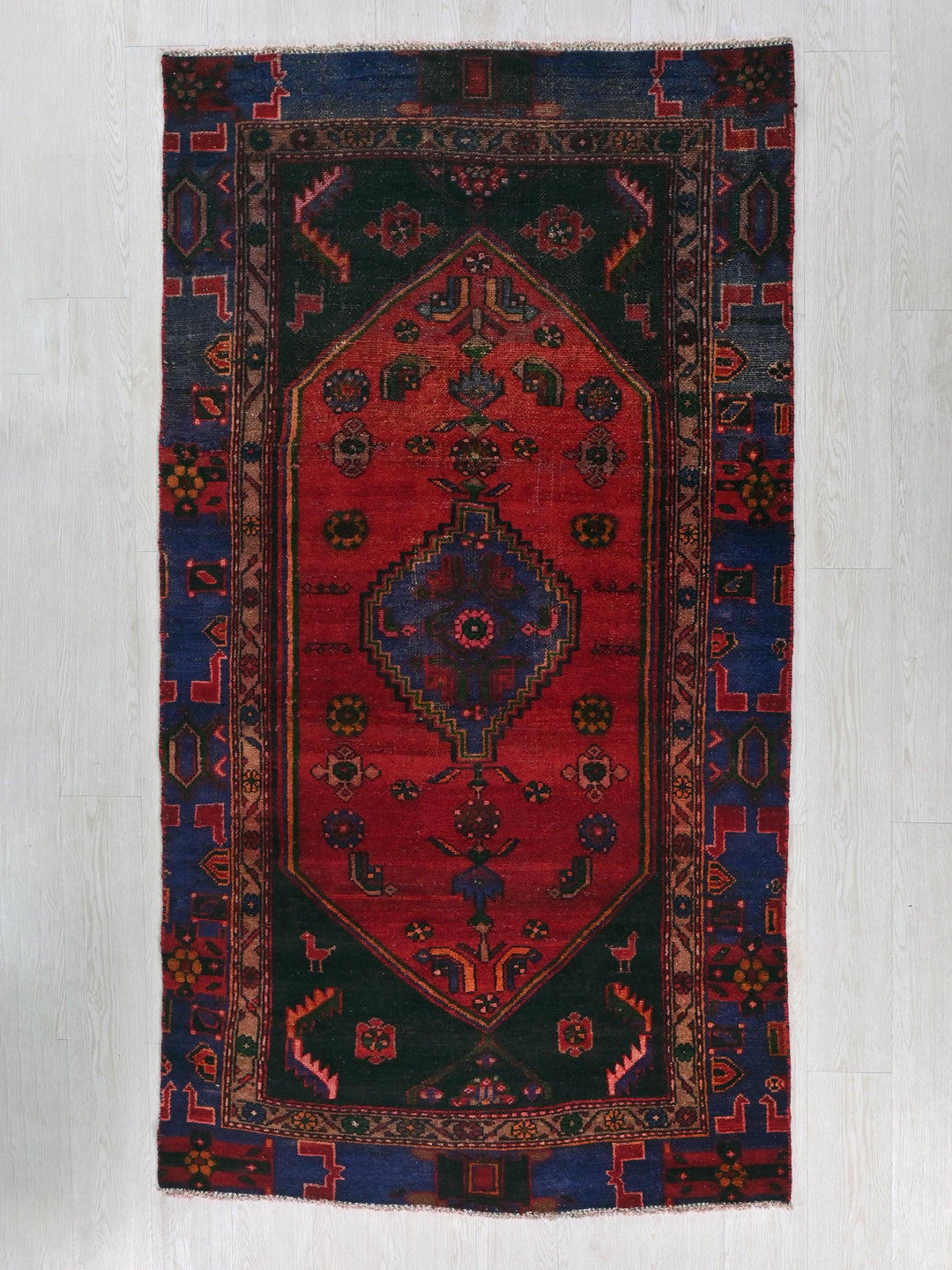 a red and blue rug hanging on a wall