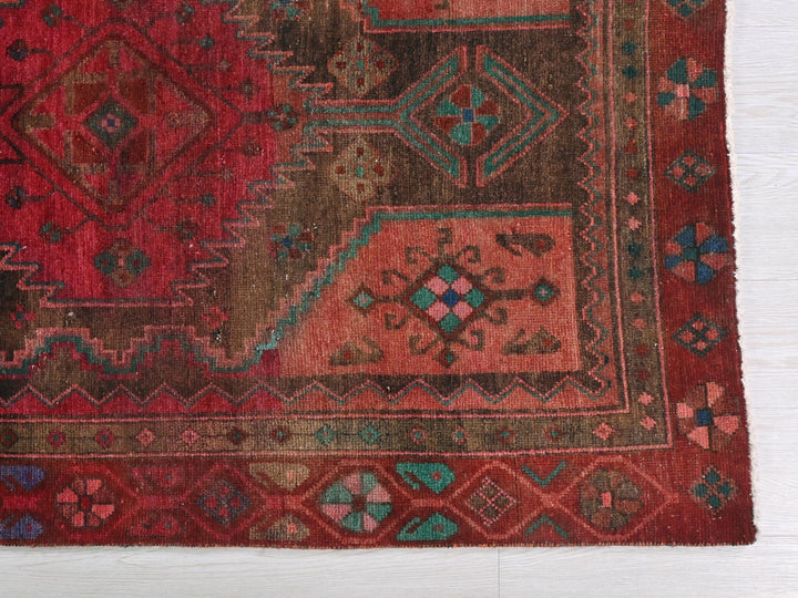 a red rug with a design on the middle of it