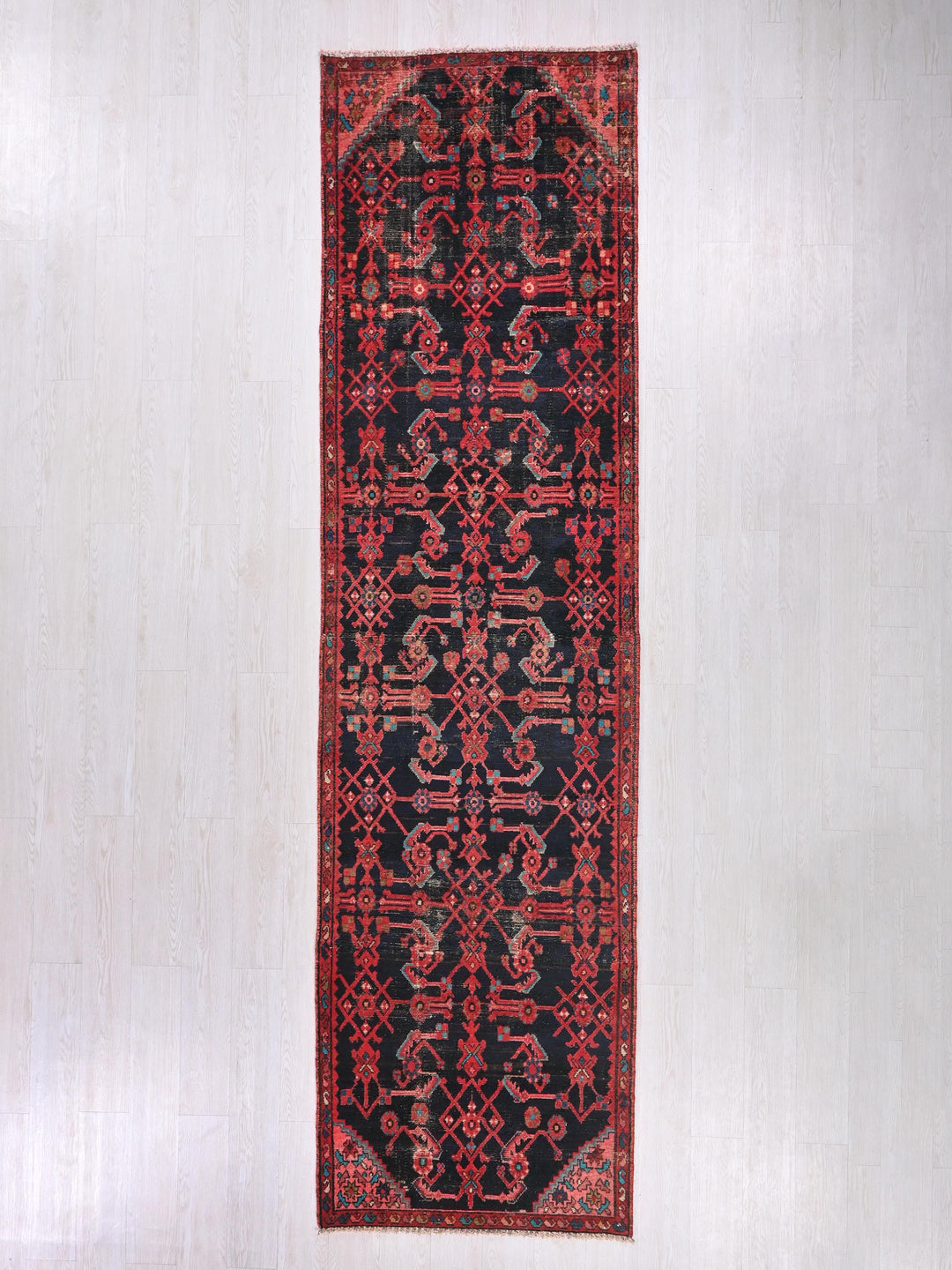 a red and black rug hanging on a wall
