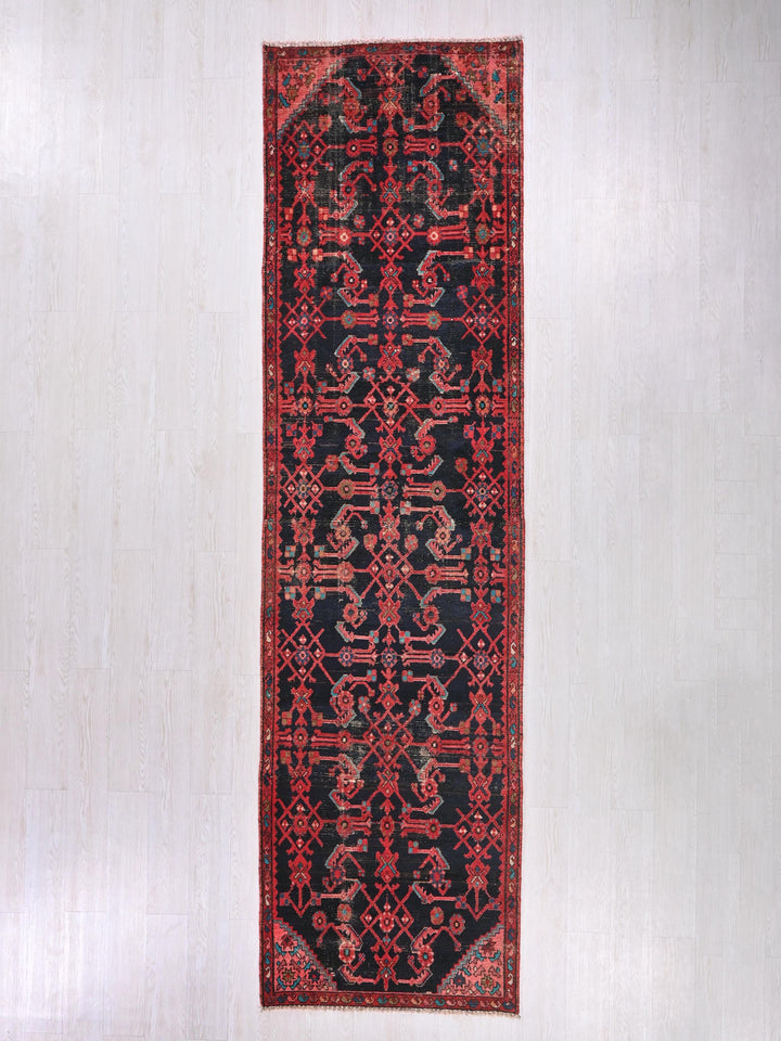a red and black rug hanging on a wall
