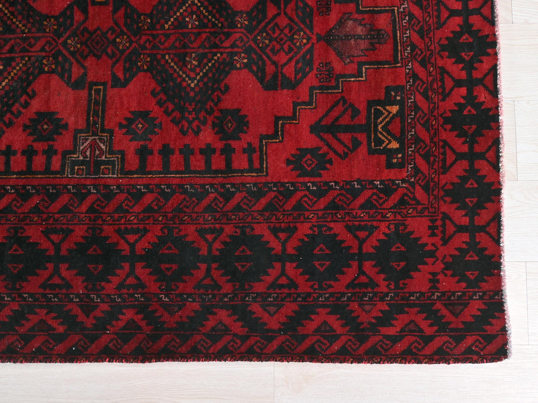 a red and black rug on a white floor