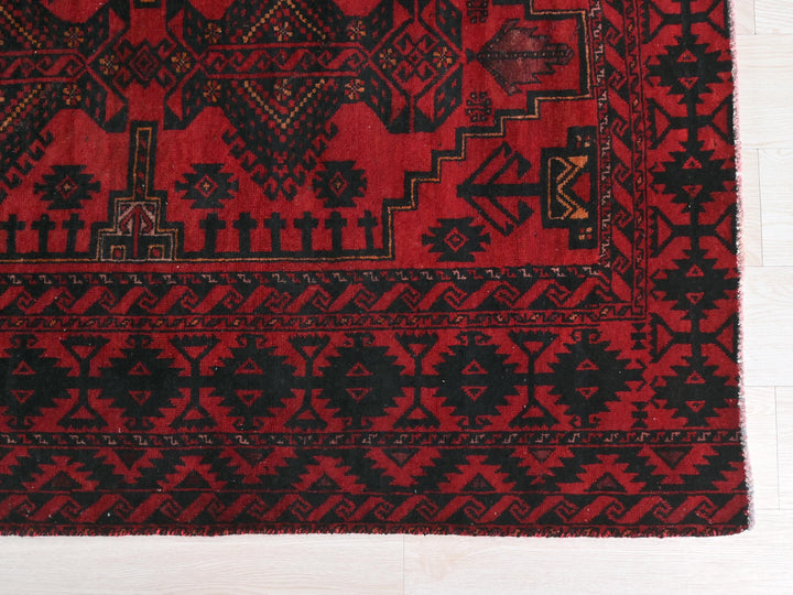a red and black rug on a white floor