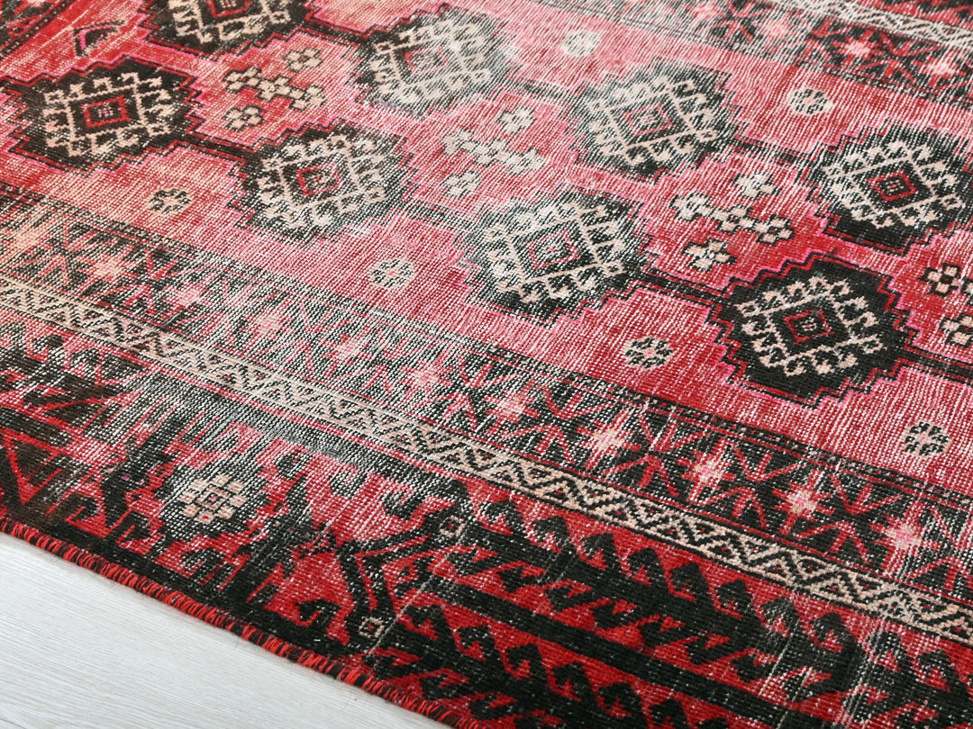 a red rug with black and white designs on it