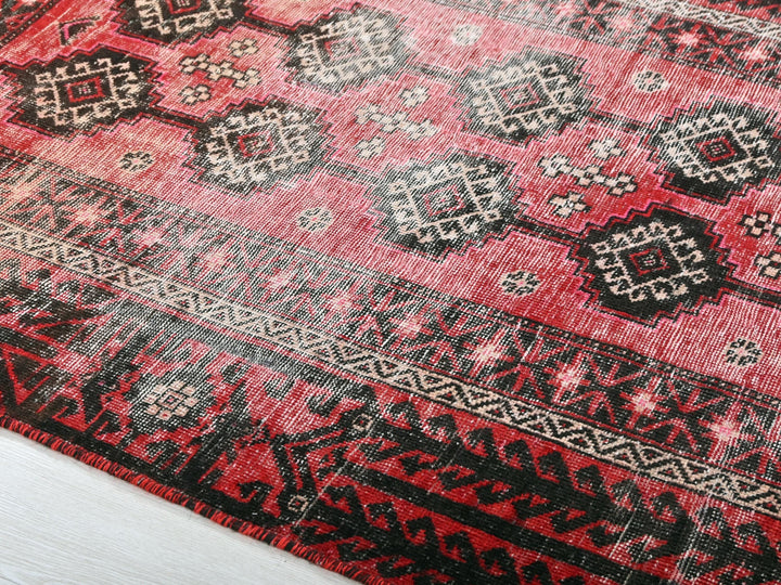 a red rug with black and white designs on it