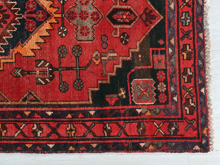 a red rug with a design on the middle of it