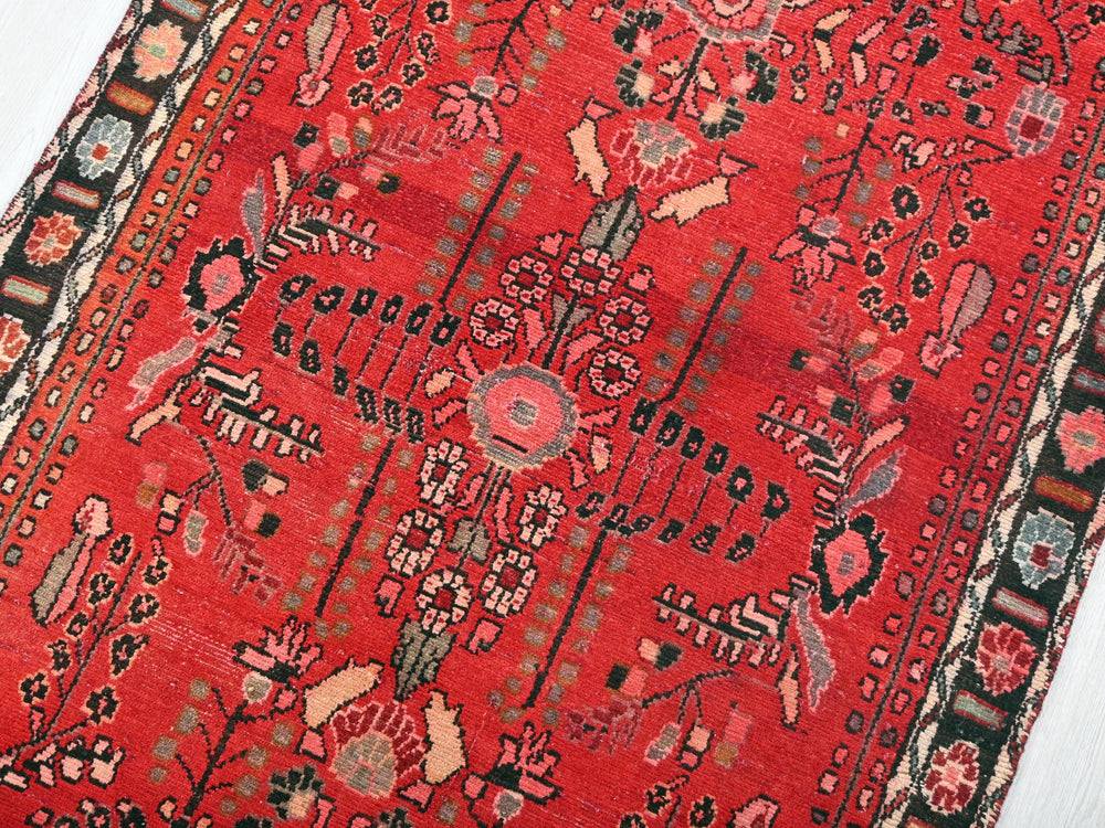 a red oriental rug with a black border