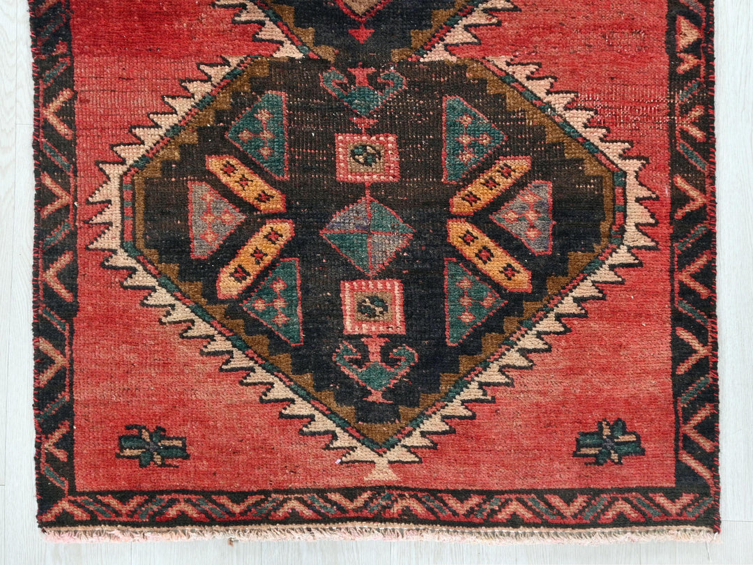 a red rug with a diamond shaped design on it