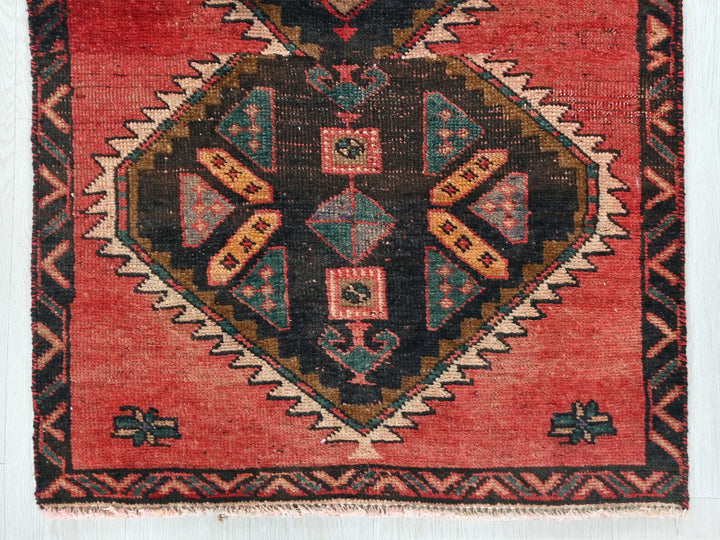 a red rug with a diamond shaped design on it