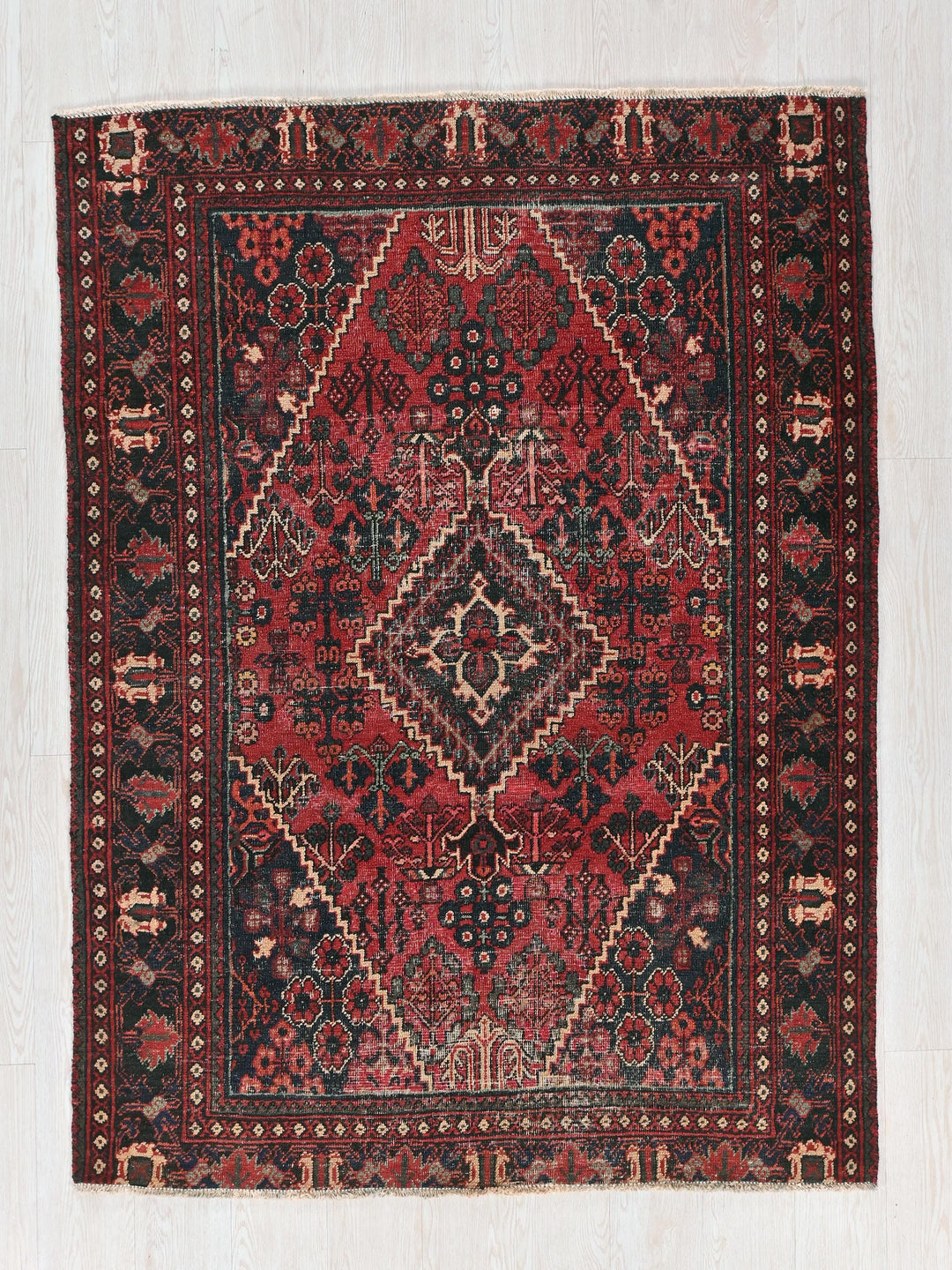 a red and black rug on a white floor