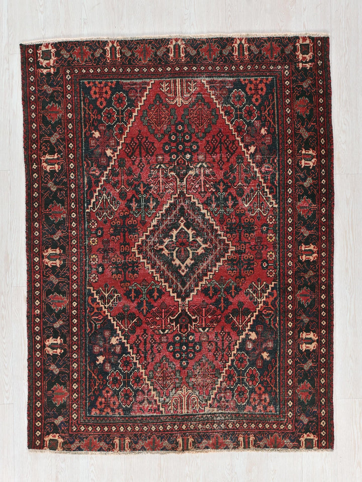 a red and black rug on a white floor