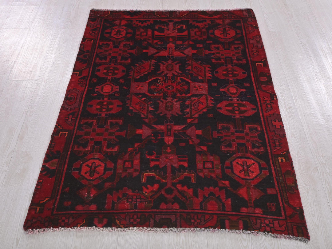a red and black rug on a white floor