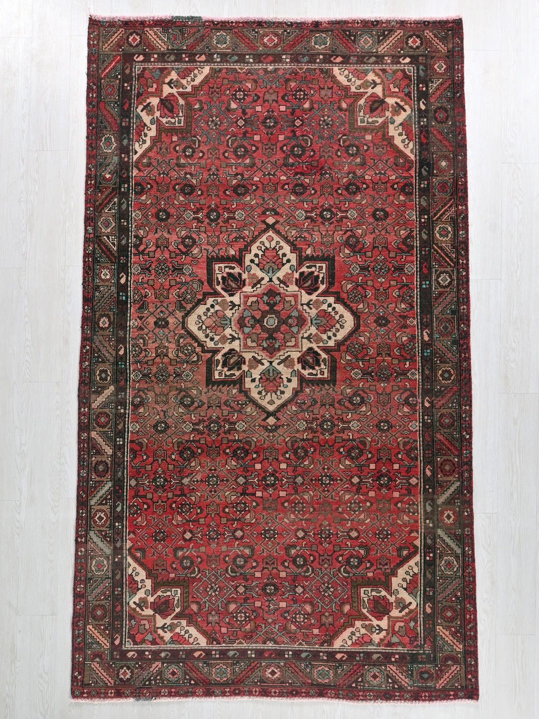 a red rug with a medallion design on it