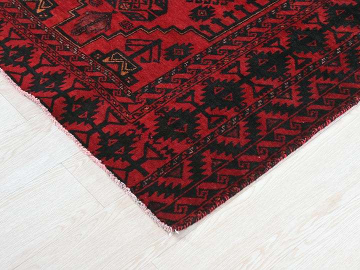 a red and black rug on a white floor