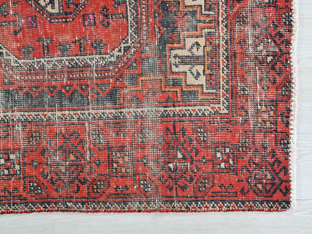 a red rug with a black and white design on it