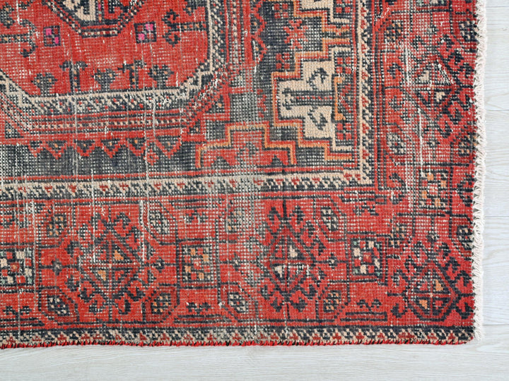 a red rug with a black and white design on it