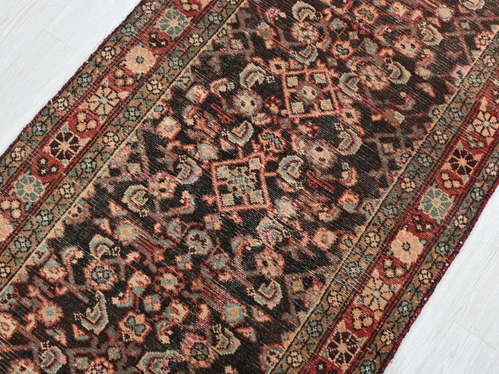 a red and black oriental rug on a white floor