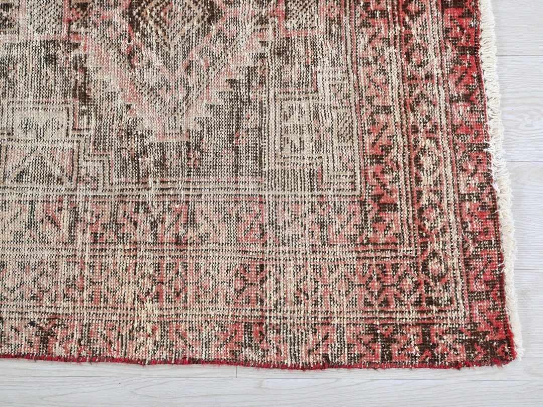 a red and white rug on a wooden floor
