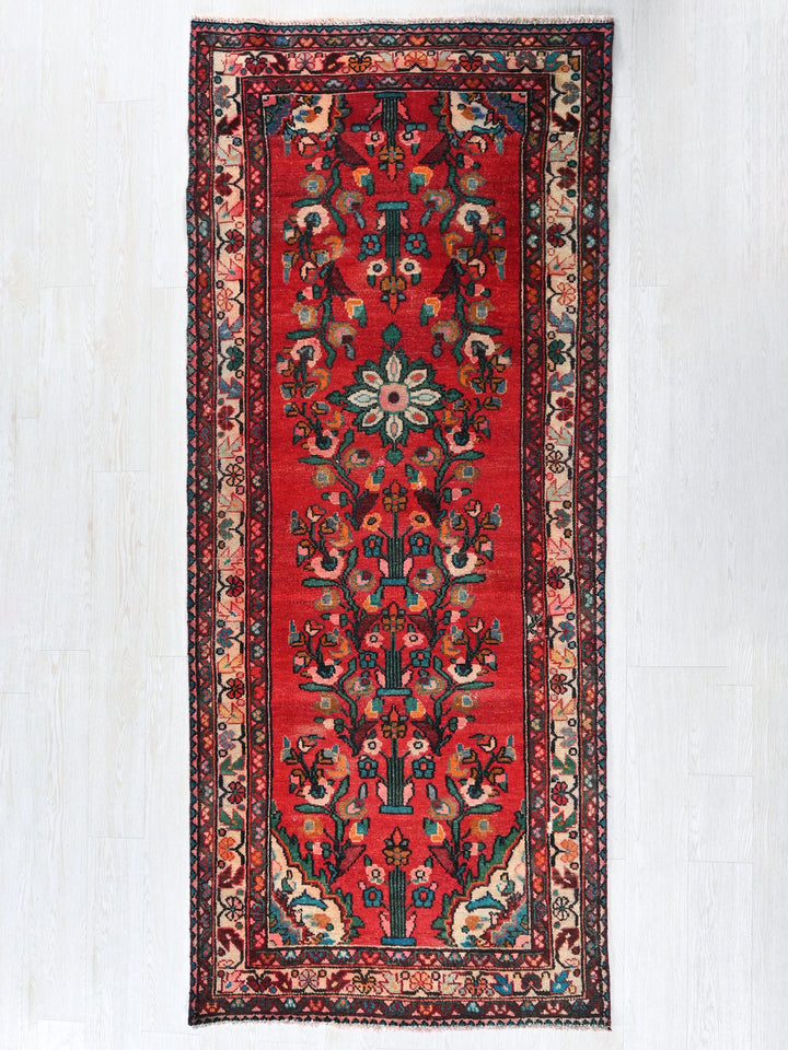 a red rug hanging on a white wall