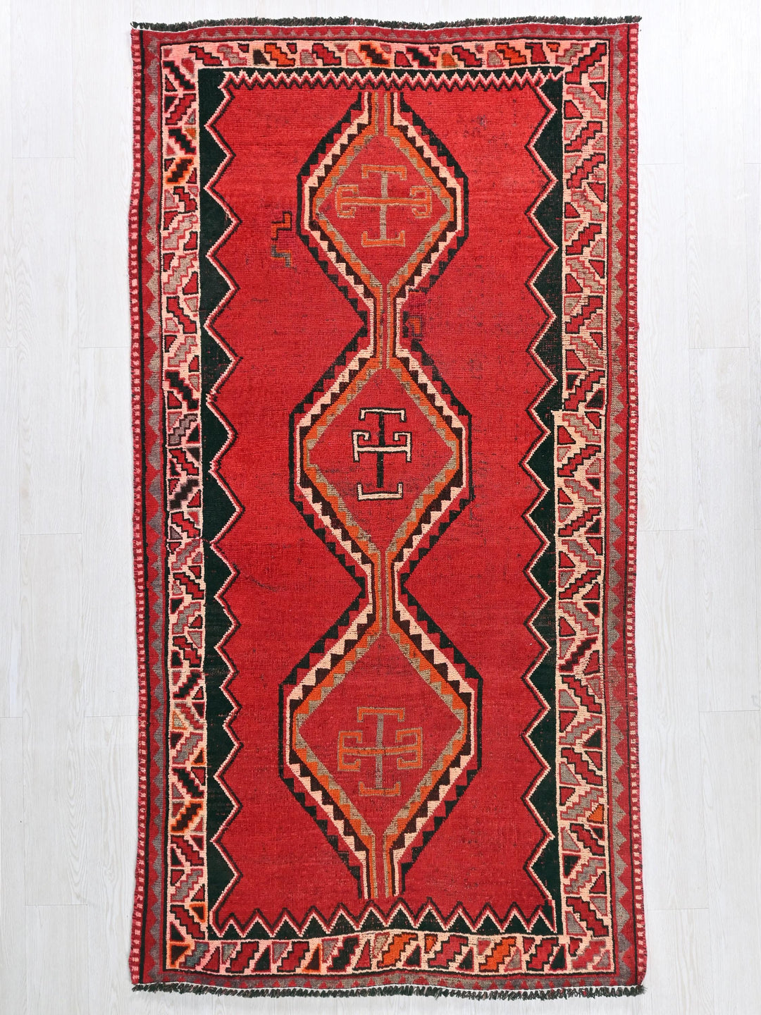 a red rug with a design on it