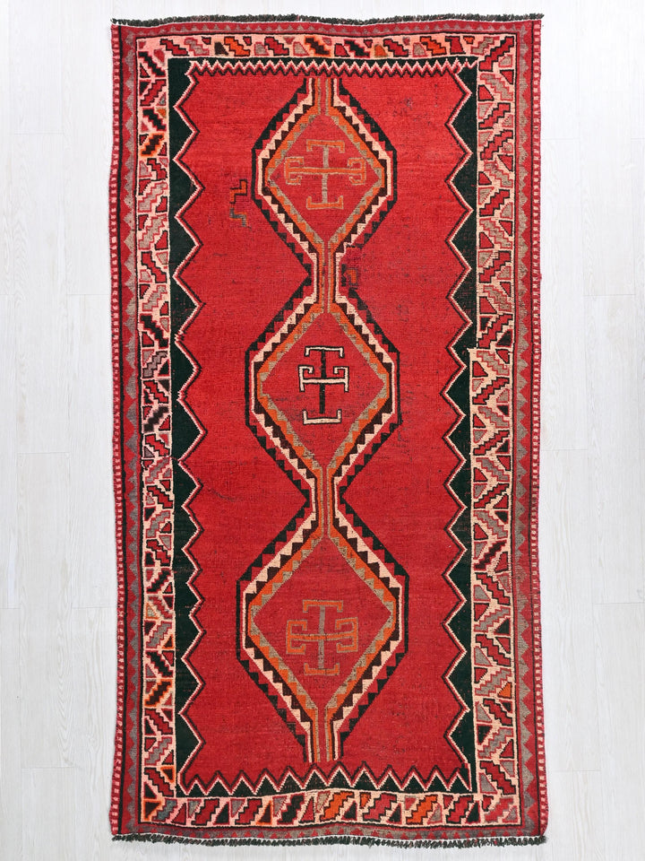 a red rug with a design on it