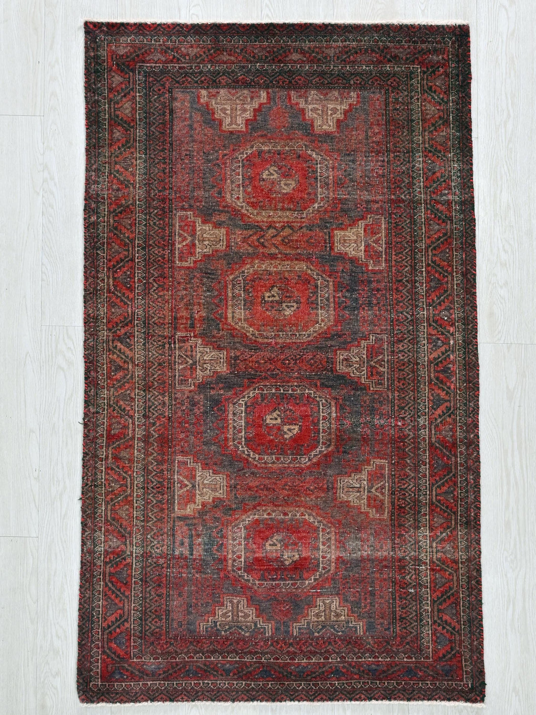 a red rug on a white wooden floor