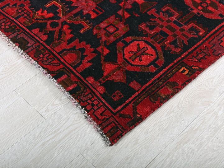 a red and black rug on a white floor