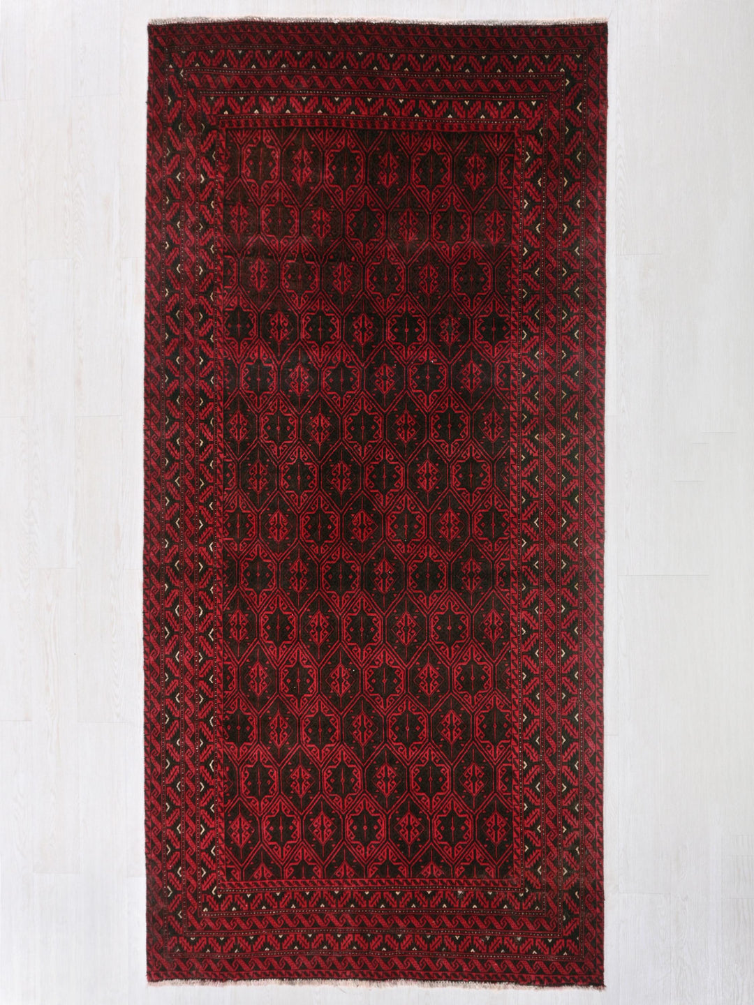a red and black rug on a white wall