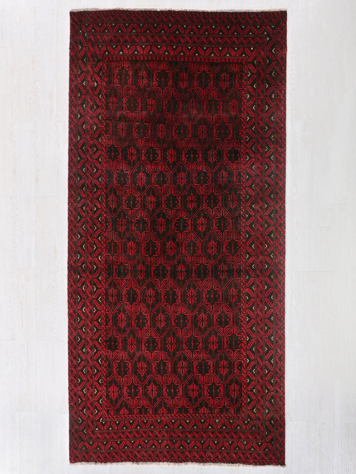 a red and black rug on a white wall