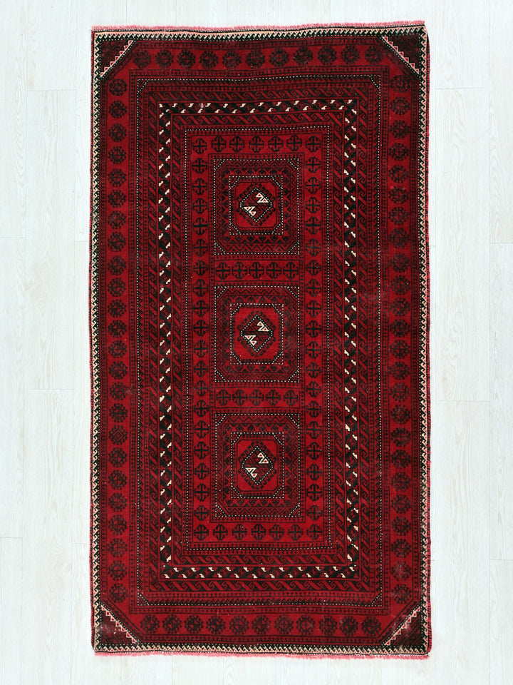 a red and black rug on a white floor