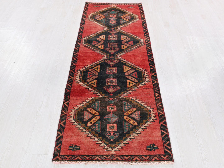 a red runner rug with a design on it