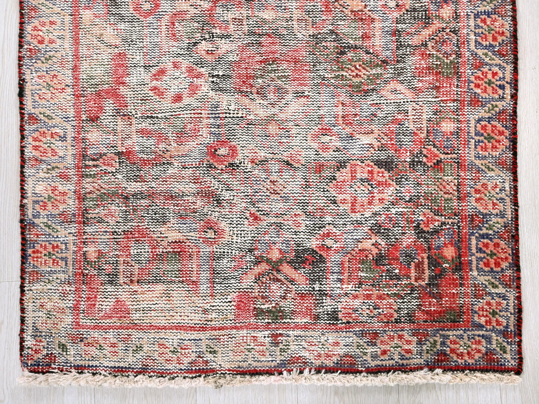 a red and blue rug on a white floor