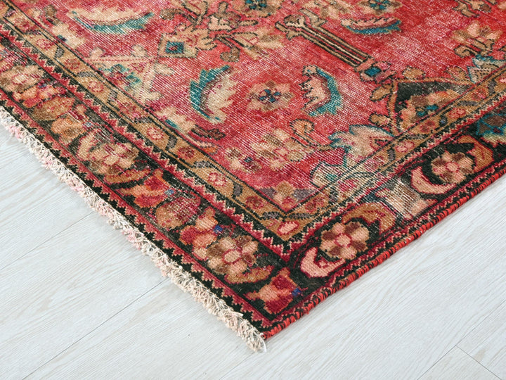 a red oriental rug on a white wooden floor