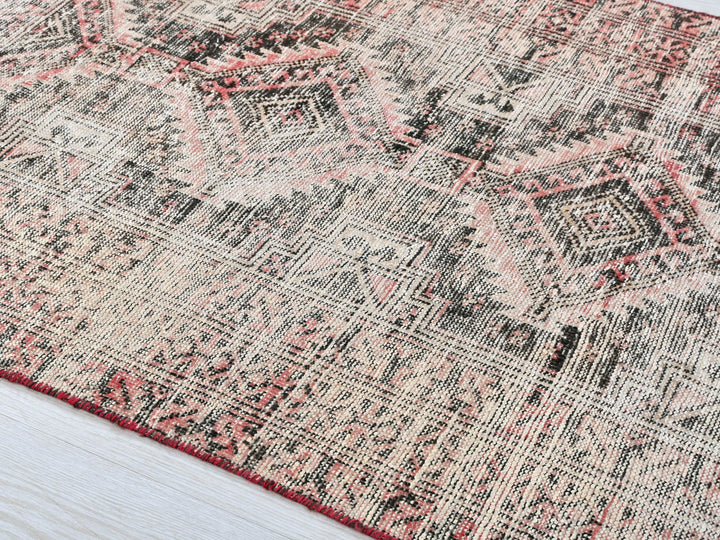 a rug with a red border on a white floor