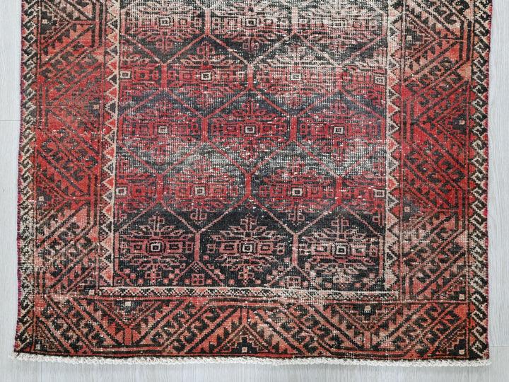 a red and black rug on a white floor