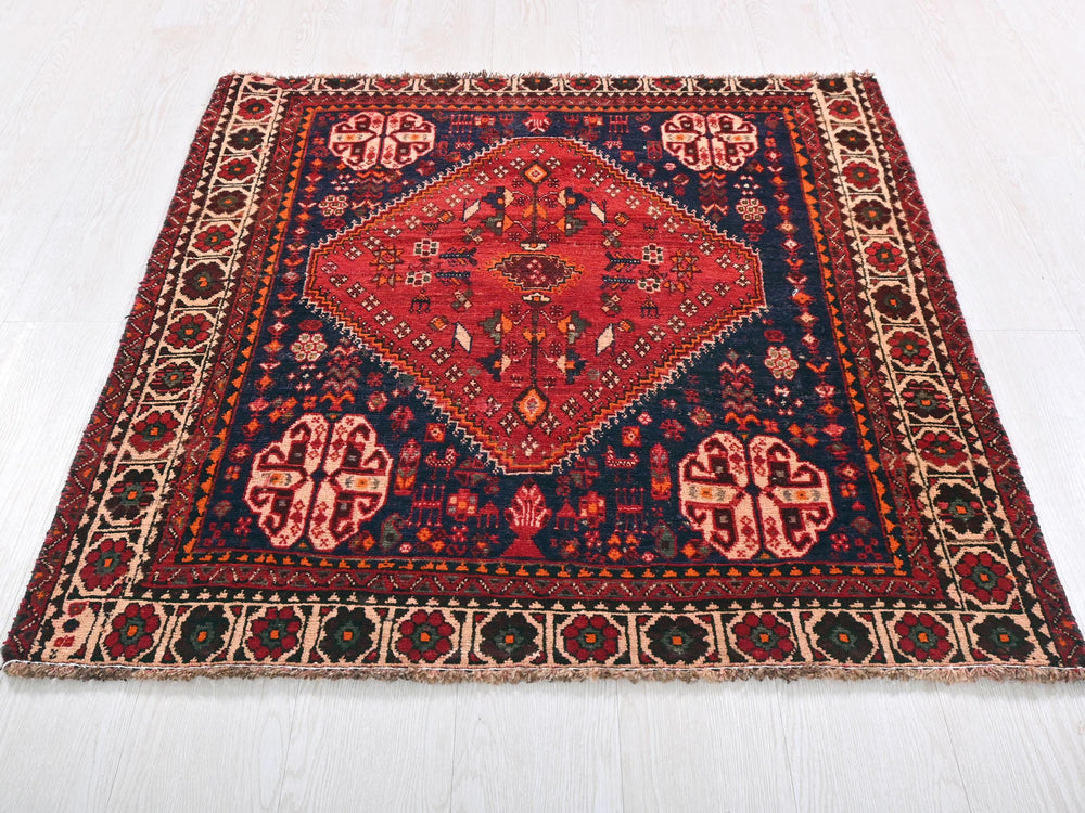 a red and blue rug on a white floor
