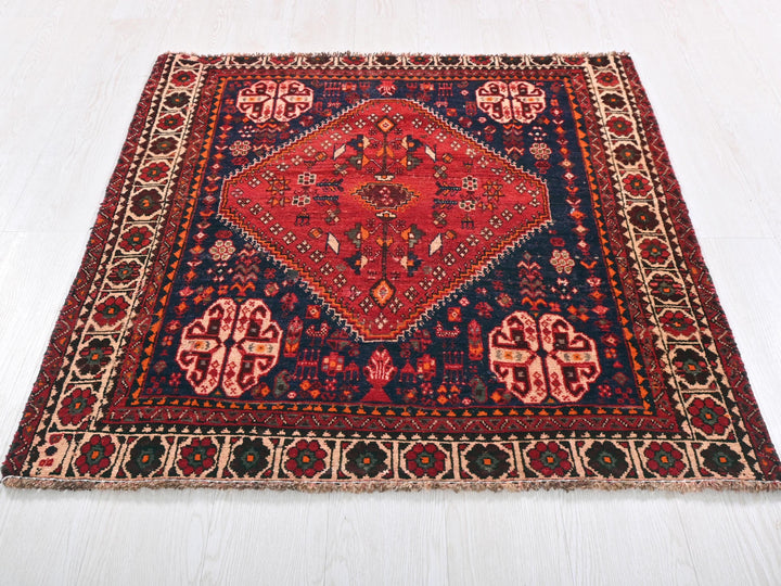 a red and blue rug on a white floor