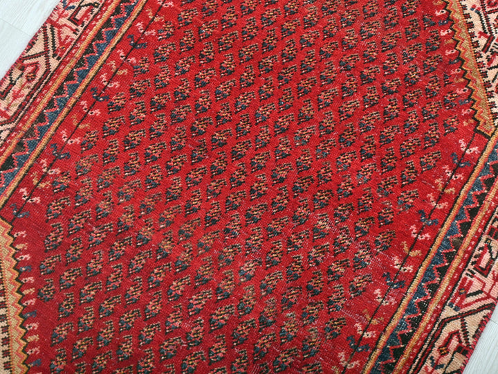 a red oriental rug on a white wooden floor