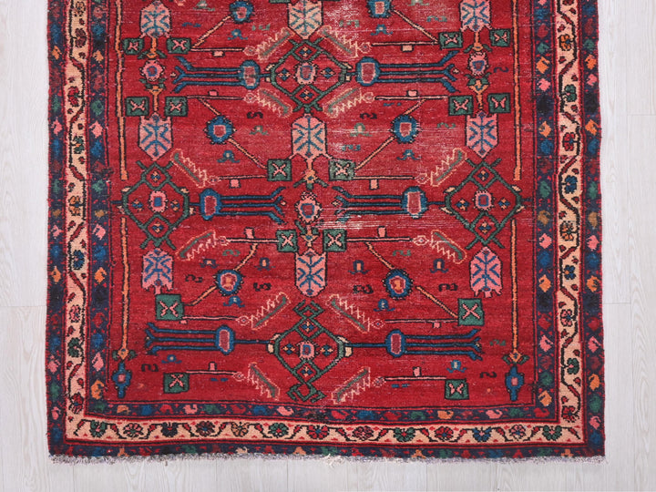 a red rug with a design on the middle of it