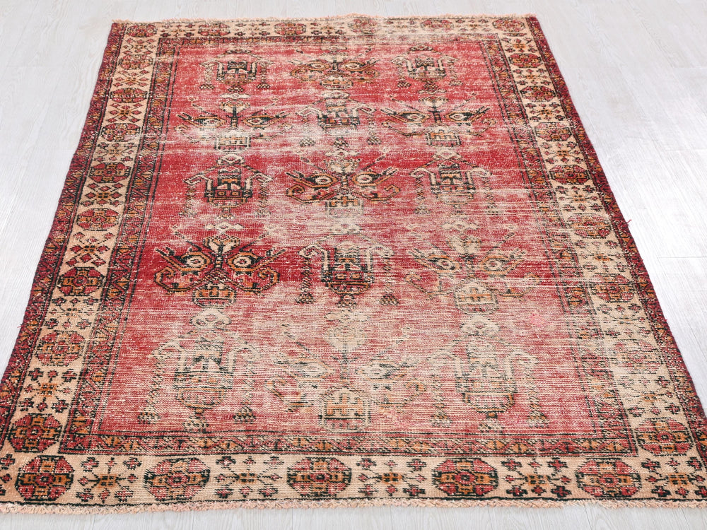 a red and beige rug on a white floor