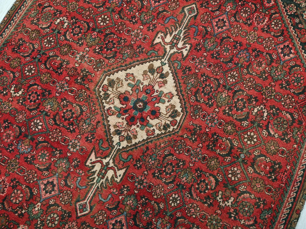 a red rug with a floral design on it