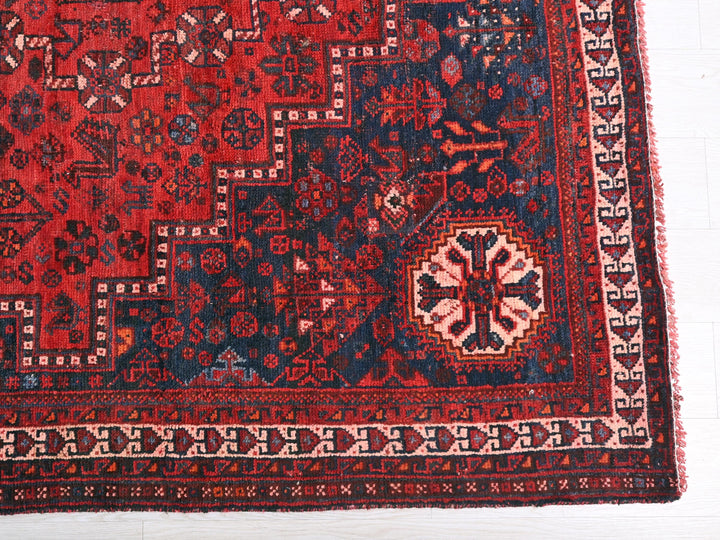 a red and blue oriental rug on a white floor