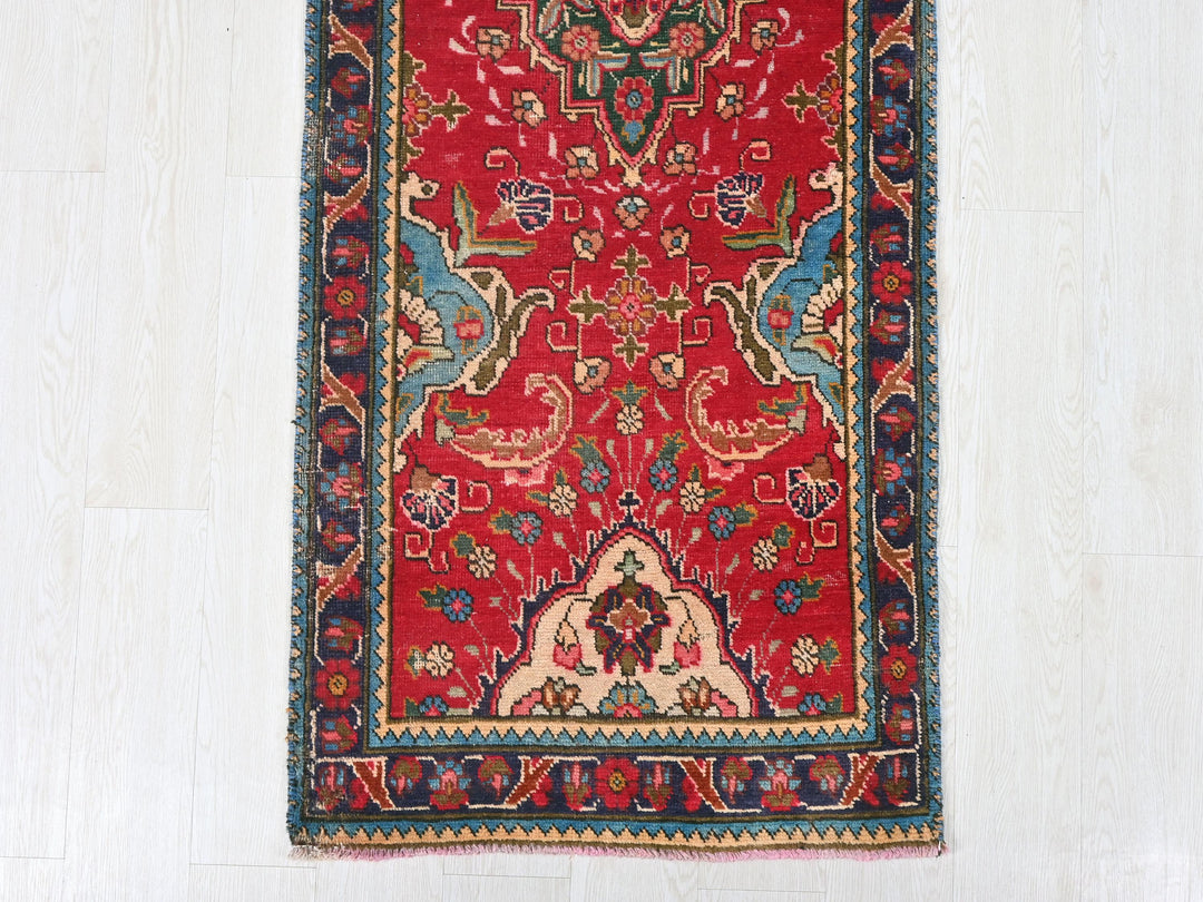 a red rug with a blue border on a white floor