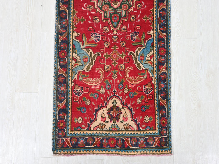 a red rug with a blue border on a white floor