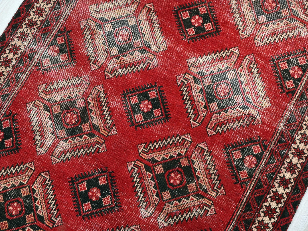 a close up of a red rug on a wooden floor