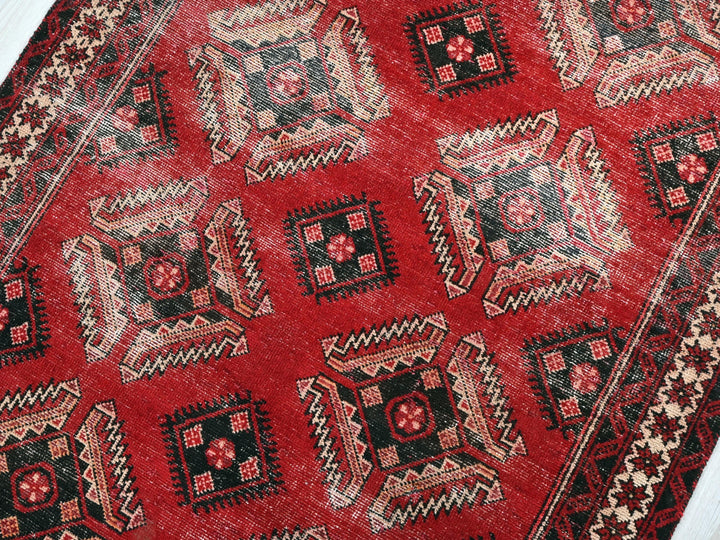 a close up of a red rug on a wooden floor