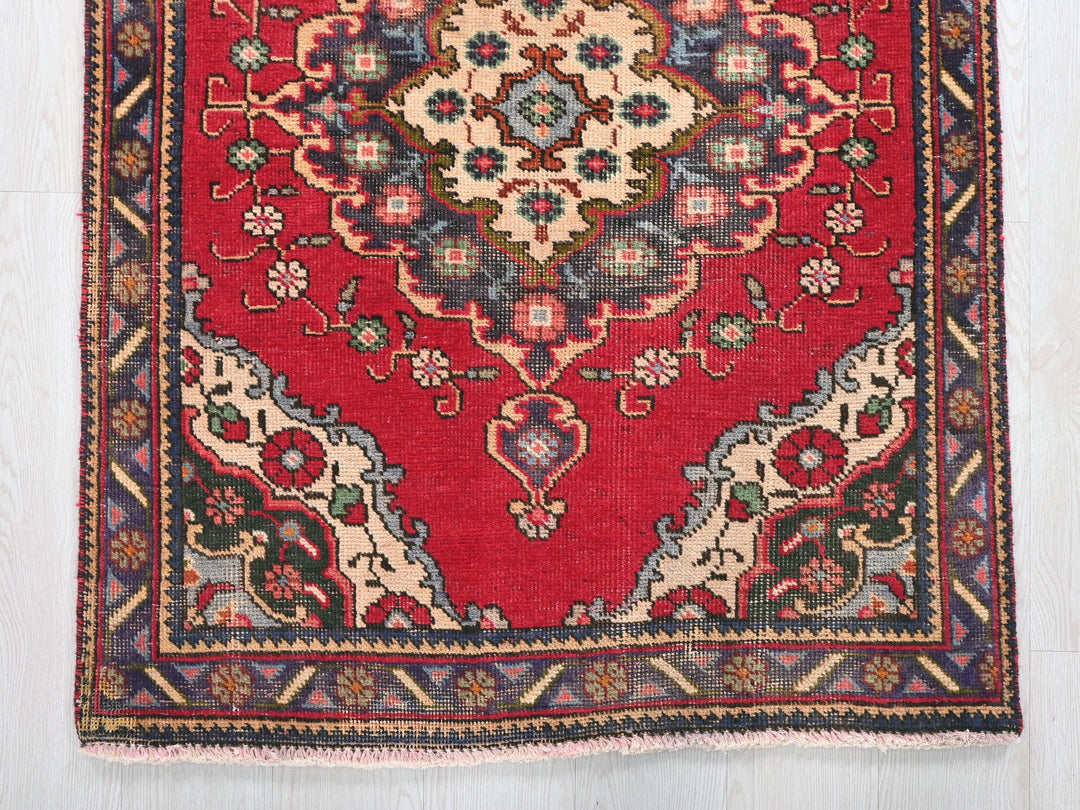 a red rug with a floral design on it