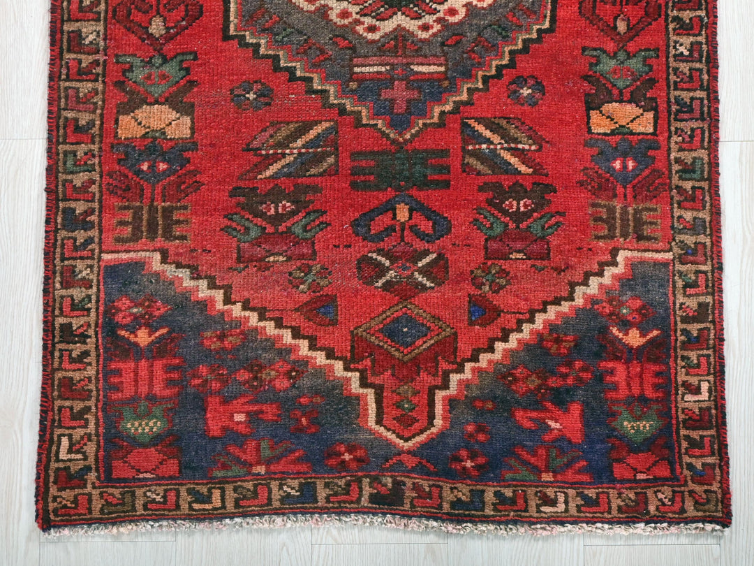 a red rug with a design on the middle of it