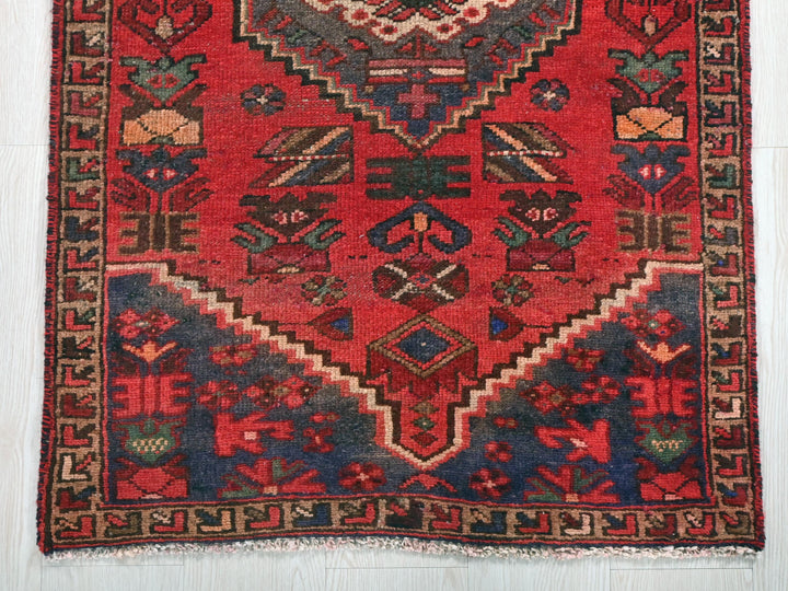 a red rug with a design on the middle of it